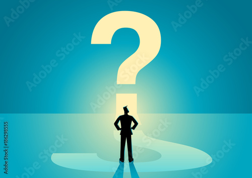 Businessman looking at big question mark