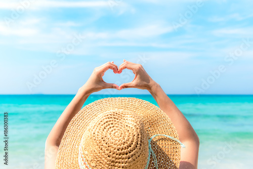 Canvas Print Woman making heart shape on the beach.  Valentine Concept.