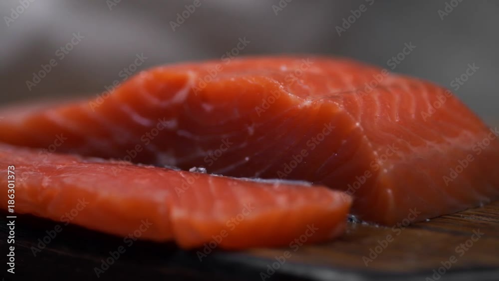 The cook cuts salmon fillet, chef prepares fish for cooking, dishes with fish, diet food