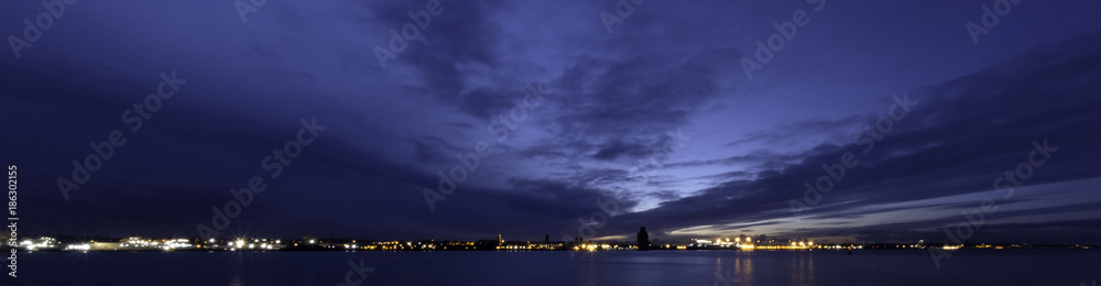 River Mersey and Birkenhead by night - panoramic view from Keel Wharf waterfront in Liverpool, United Kingdom