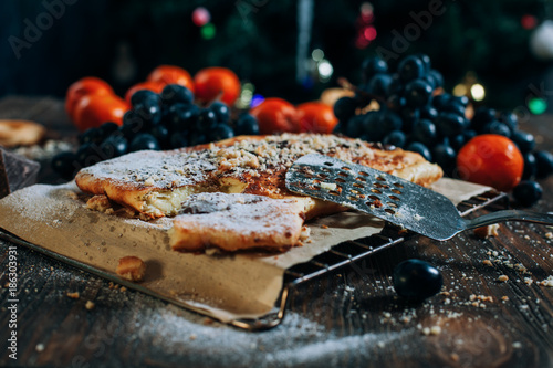 cheese cake with chocolate, biscuits, tangerines, grapes on a wooden table