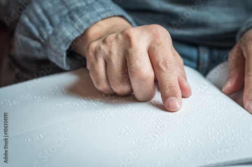 World braille day concept with blind person reading braille text touching the relief on book with finger photo