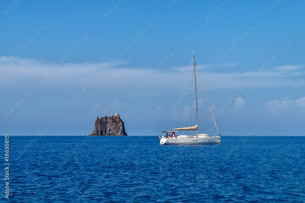 White sailing yacht near Strombolicchio island, Italy
