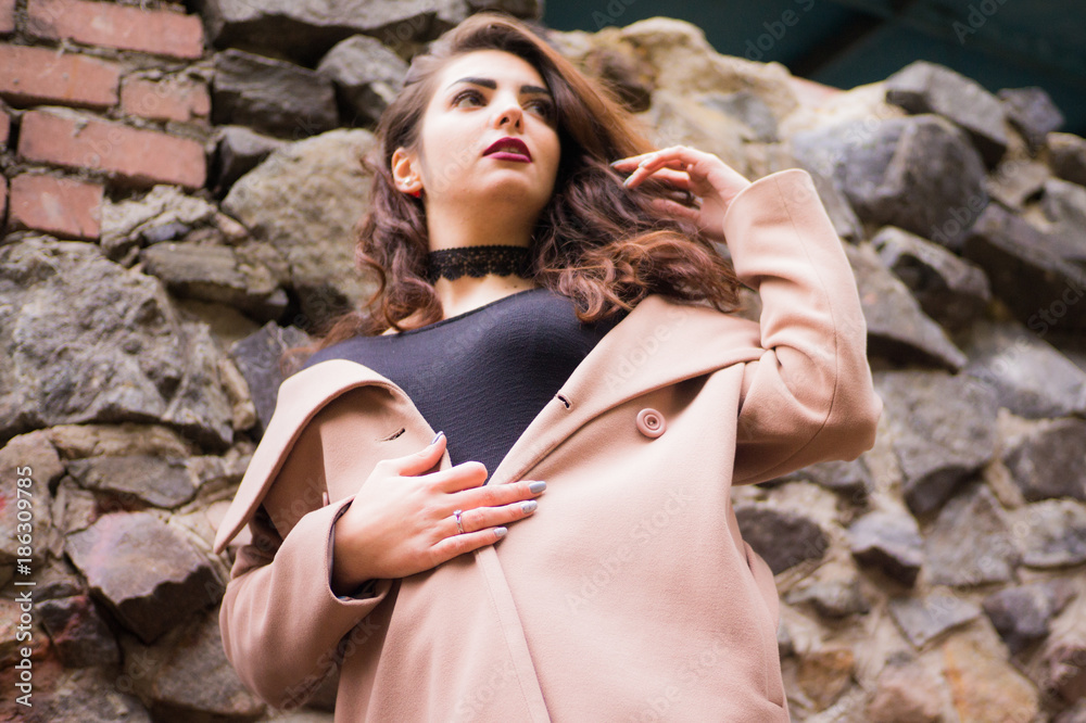 curly-haired girl in a beige coat curly-haired girl in a beige coat