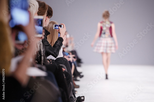 Woman taking picture of new model on fashion show photo
