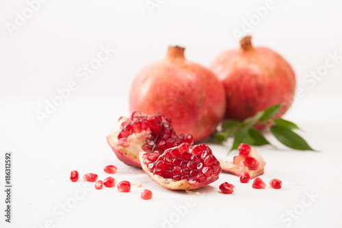 Pomegranate fruits with peeled pomegranate on a white
