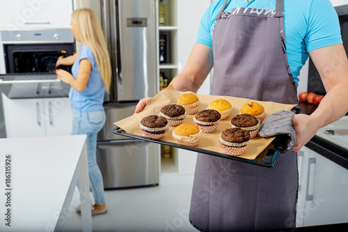 A couple is preparing a capkake in the kitchen together. photo