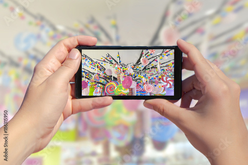 Fotografía Women's hands take a picture of many candies on a smartphone