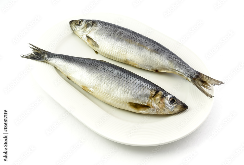 Salted herrings on the plate, isolated on white background. Salted herrings on the plate, isolated on white background.