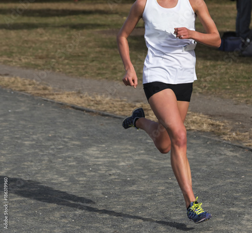 Female Cross Country runner racing on a gravel path