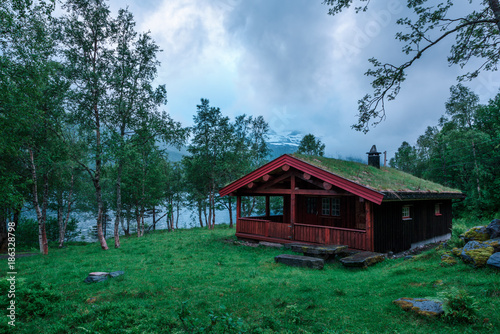 Typical norwegian old wooden houses with grass roofs near forest lake, Norway. © Ivan Kmit