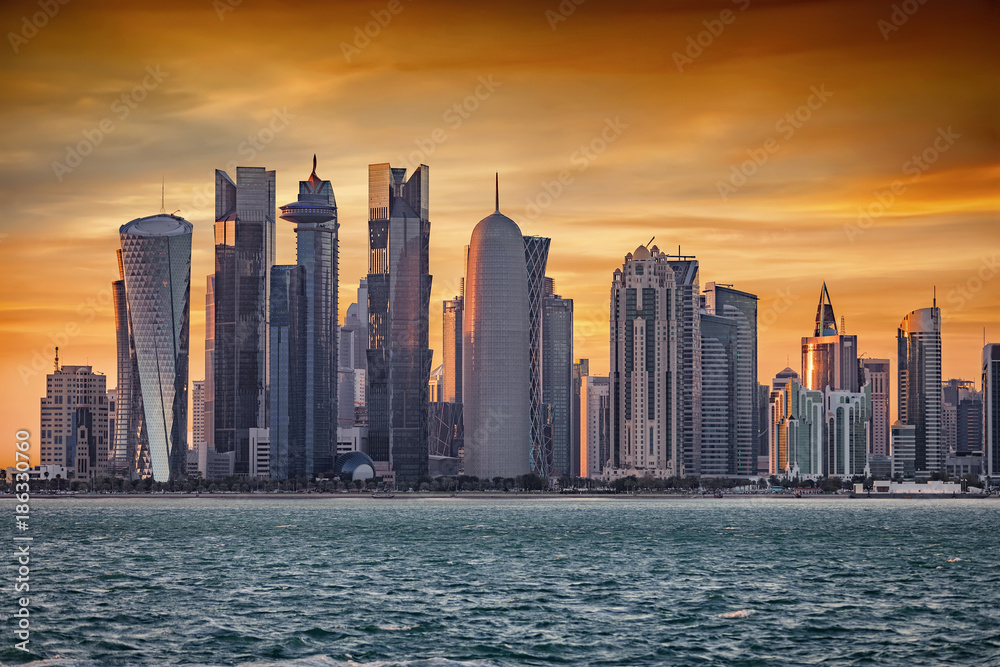 Obraz premium Das moderne Zentrum mit zahlreichen Wolkenkratzern in Doha, Katar, bei Sonnenuntergang