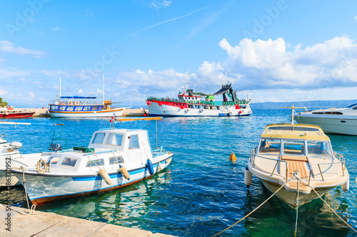 Bol port with fishing boats and passenger ferry to Hvar island in background, Brac island, Croatia