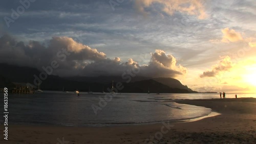 Wide, scenic sunset over beach mountains in Hawaii