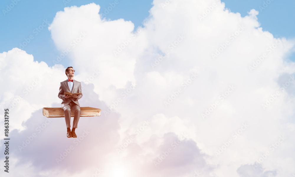 Young businessman or student floating in blue sky and studying the science Young businessman or student floating in blue sky and studying the science