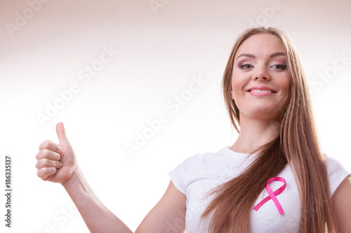 woman pink cancer ribbon on chest making thumb up