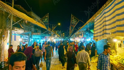 The busy evening in Ganjali Khan Bazaar -  central grocery market with wide range of fresh fruits, vegetables, spices and other goods, Kerman. 
