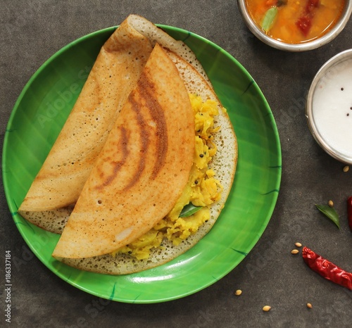 Dosa - South Indian Breakfast crepes served with chutney and sambar, top view photo