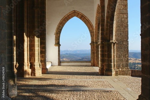 Herrlicher Panoramablick durch einen gotischen Torbogen, Iglesia Prioral de Nuestra Señora del Mayor Dolor, Aracena, Andalusien photo