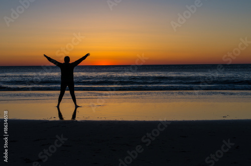 young woman watching the sunrise over the ocean