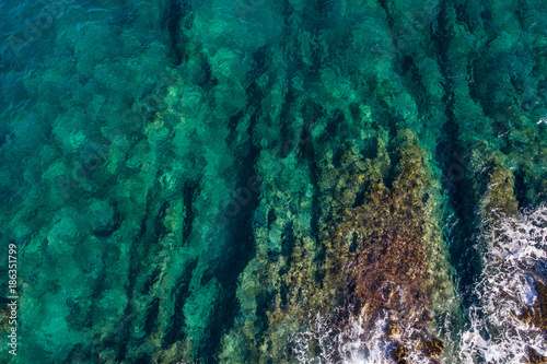 Aerial view of the green waves that beat the sea cliffs