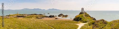 Lighthouse at Ynys Llanddwyn in Anglesey, Gwynedd, Wales, UK - with Snowdonia mountain range in the background photo