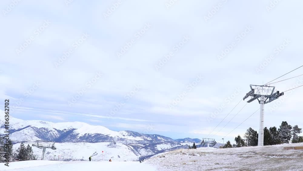 Ski station in the mountains. There is a cable car for skiers. The tops of the snow-capped mountains can be seen. Ski station in the mountains. There is a cable car for skiers. The tops of the snow-capped mountains can be seen.