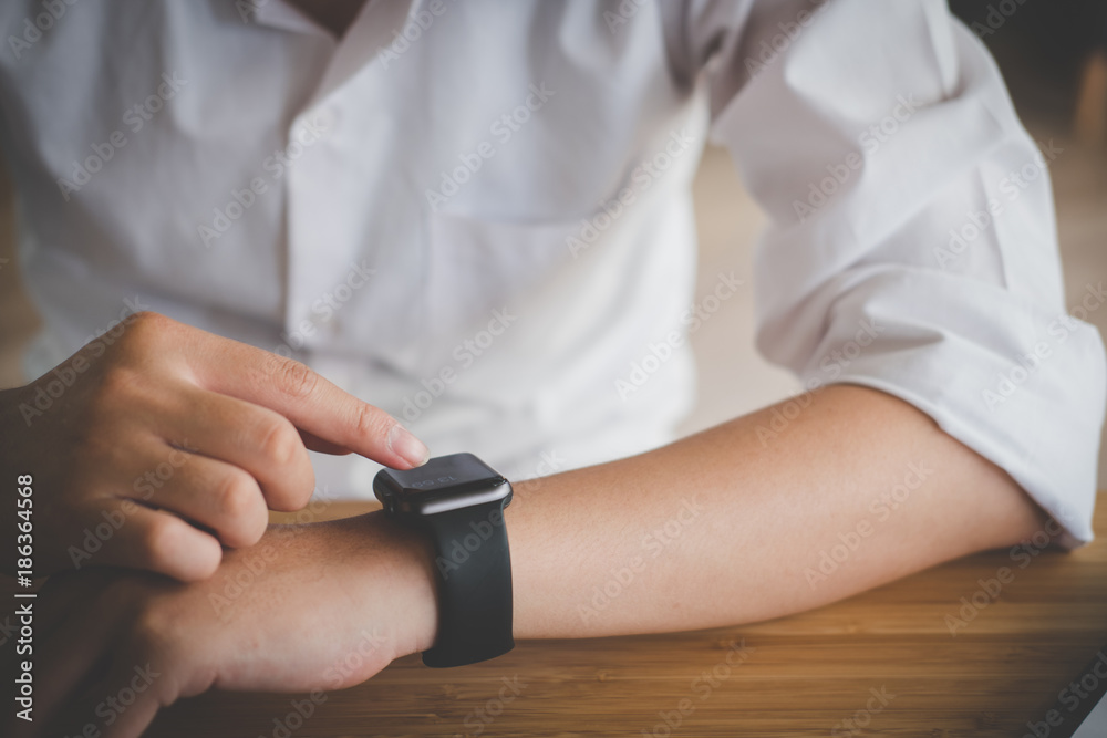 businessman look at smartwatch at workplace. startup man check time on wristwatch.  young male entrepreneur working at office.