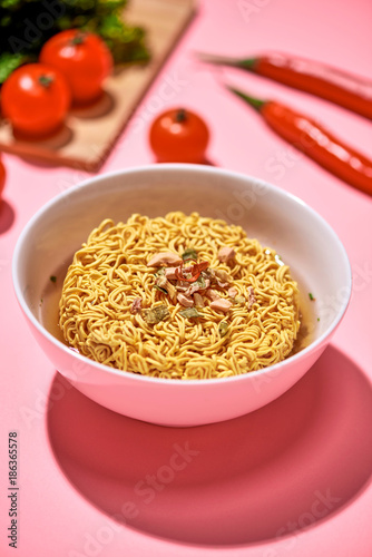 A Bowl of instant noodles on pink background