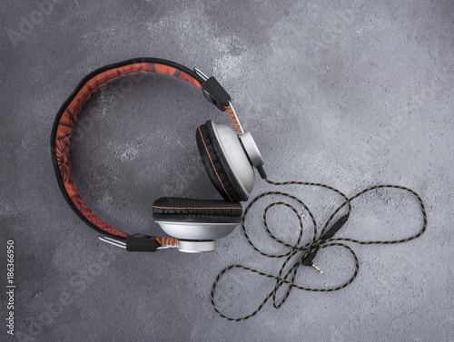 Pair of modern black and orange headphones on a grey rustict background photo