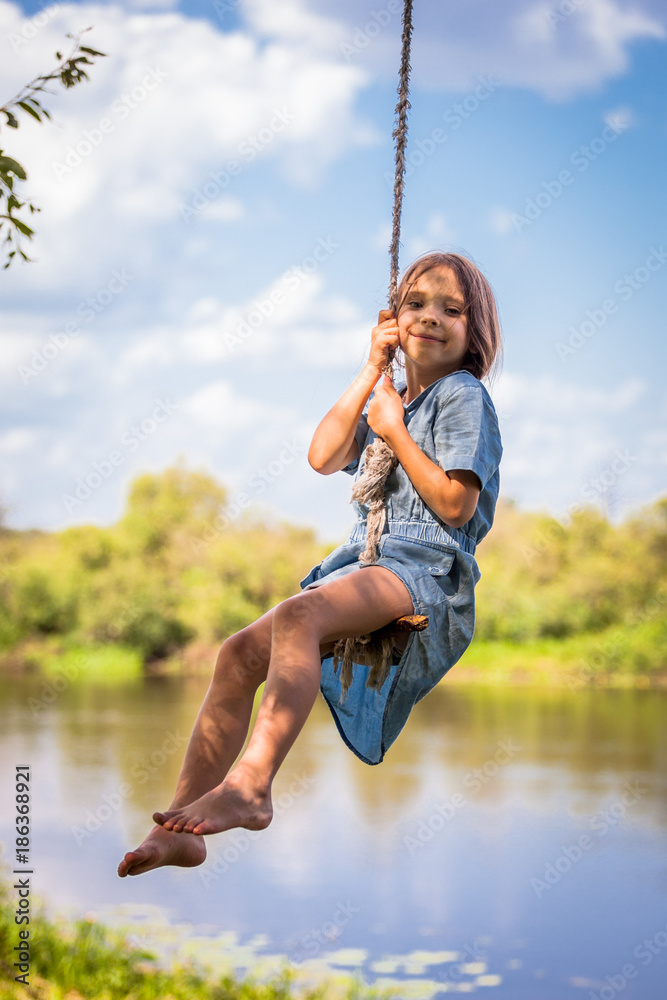 Cute girl swinging on the tree