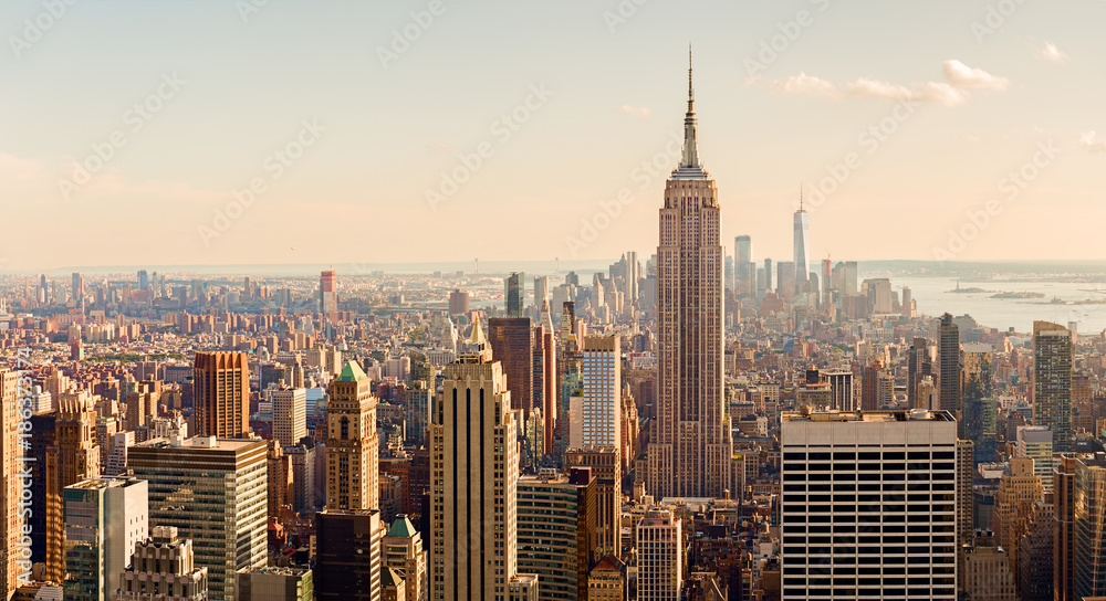 Naklejka premium Manhattan Midtown Skyline z oświetlonymi wieżowcami o zachodzie słońca. NYC, USA