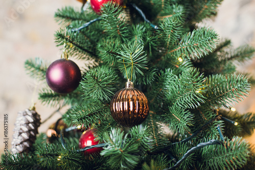 Christmas tree with garlands on a brick wall background