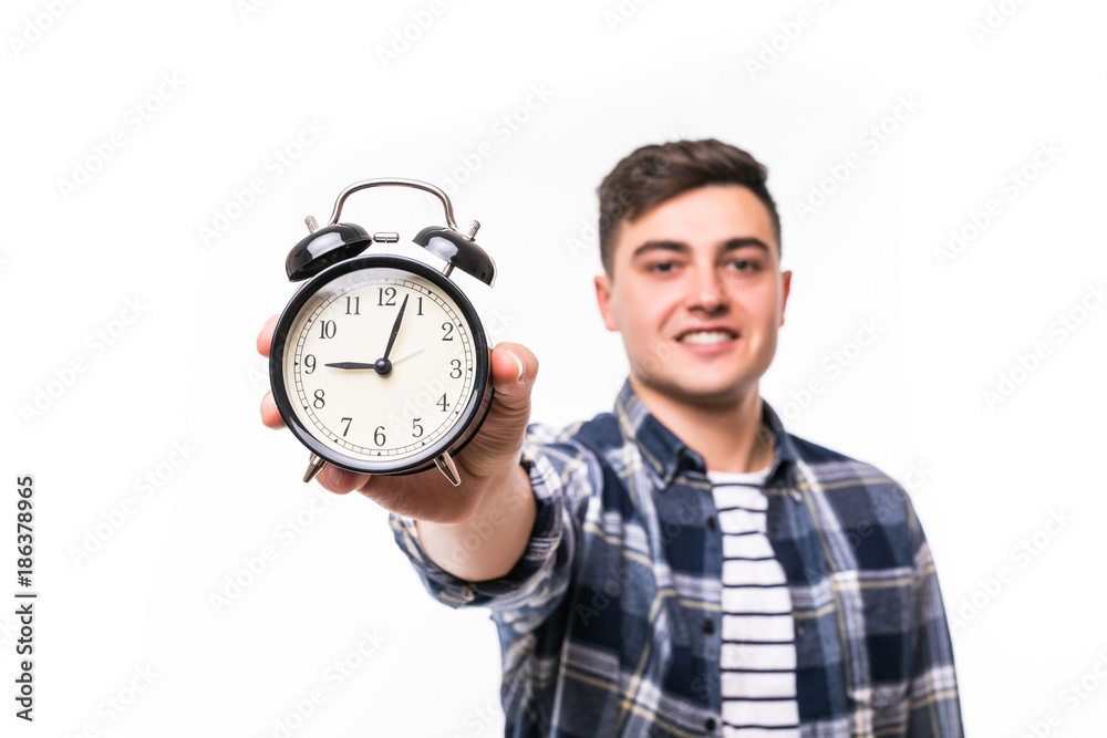 young man holding an alarm clock isolated on white background young man holding an alarm clock isolated on white background