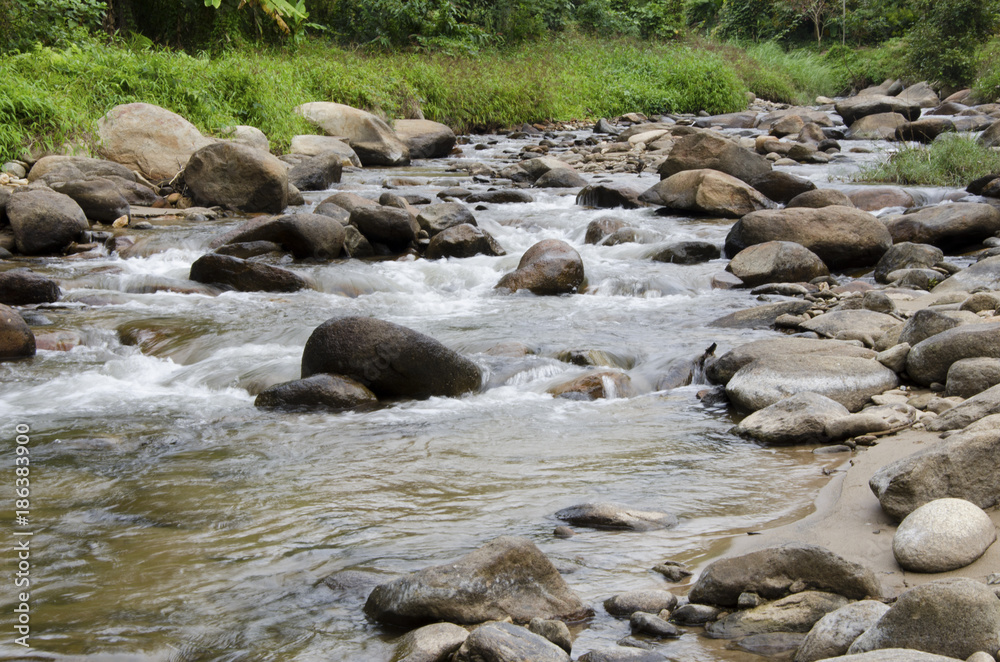 The stream flows through the rocks. The stream flows through the rocks.