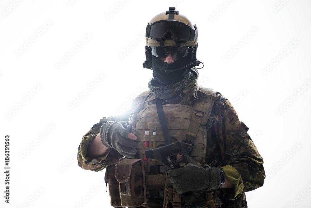 Fototapeta premium Portrait of serene defender holding assault rifle while looking at camera. Army concept. Isolated