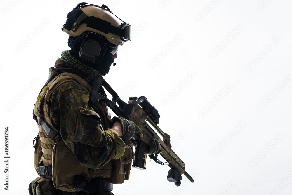 Side view serious peacemaker holding assault rifle in hands. Military concept. Isolated and copy space