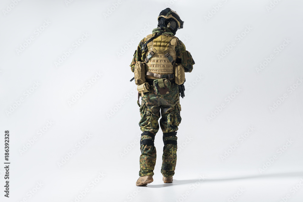 Full length soldier facing away while wearing protective military uniform. Maintenance concept Full length soldier facing away while wearing protective military uniform. Maintenance concept