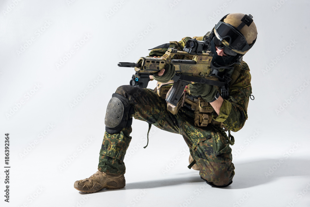 Portrait of serious defender looking at sniper scope of modern weapon. Military concept Portrait of serious defender looking at sniper scope of modern weapon. Military concept