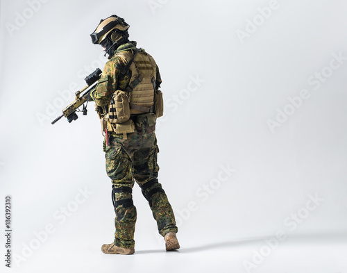 Tablou canvas Full length side view serene defender in army clothes keeping assault rifle