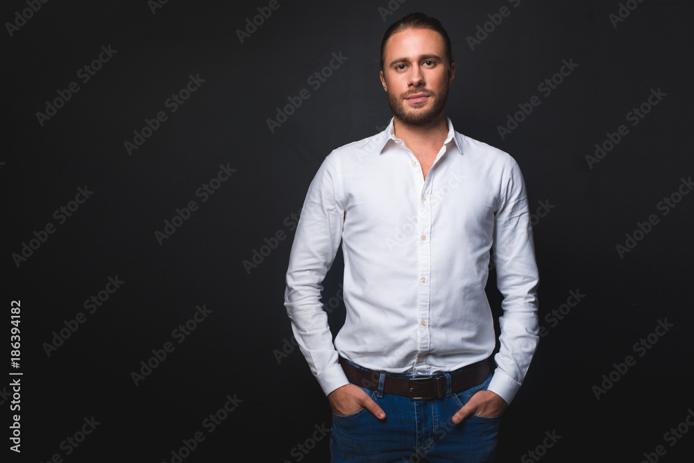 Waist up portrait of tranquil man looking at camera. Isolated on black background. Copy space in left side Waist up portrait of tranquil man looking at camera. Isolated on black background. Copy space in left side