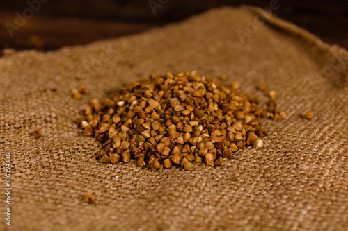 Pile of the raw buckwheat on sackcloth