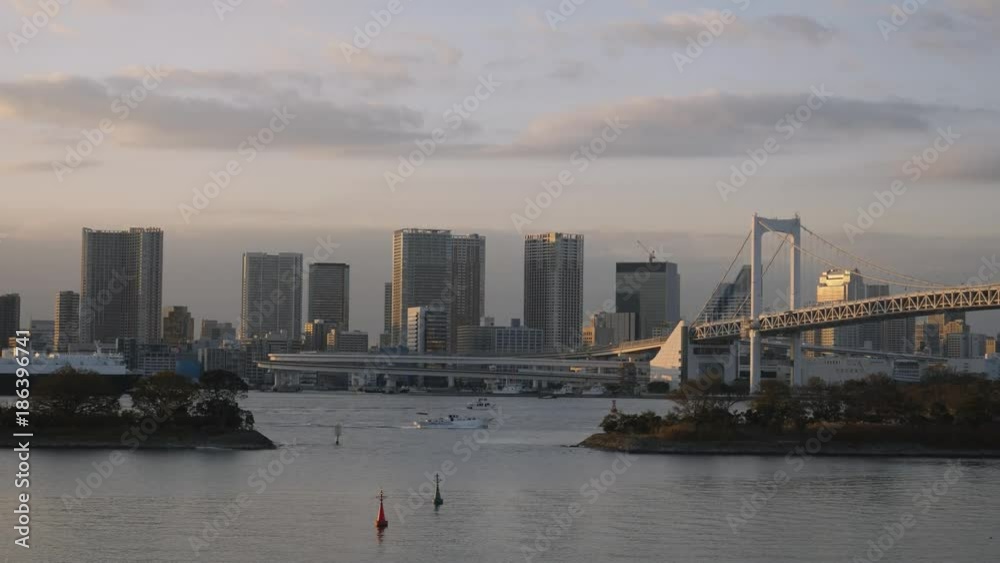 View of Tokyo city from the shore with water and tall buildings.