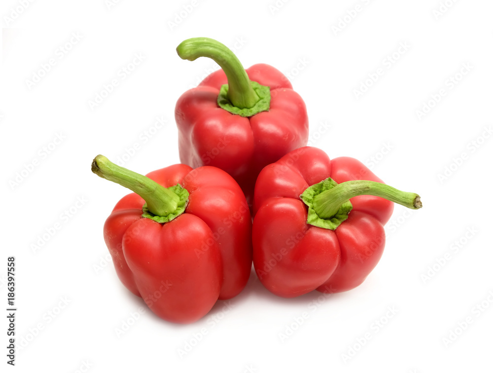 Still life with three whole red ripe bell peppers isolated on white background close up