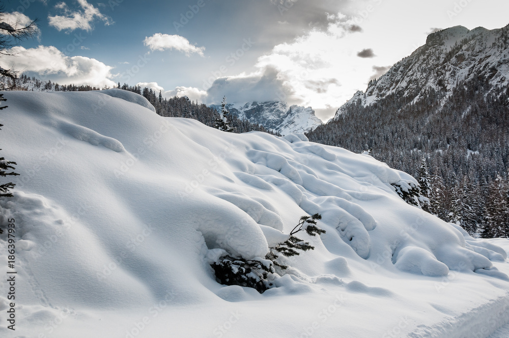 Snowdrifts with Mount Civetta in the background with the top covered with clouds