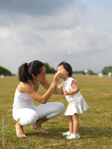 asian chinese mother helps child cleans her nose