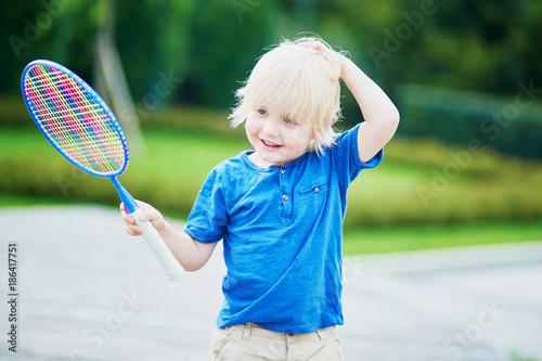 Little boy playing badminton on the playground