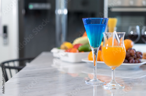 Cocktail and Orange juice in glass at kitchen room on marble table with fruits and vegetables healthy diet food concept, Copy space the left.