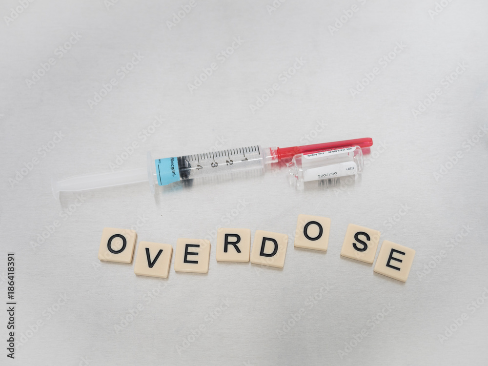 Tan tiles with black capital letters spelling Pain Killer with a syringe and empty glass Fentanyl vial on a tan tile background. Tan tiles with black capital letters spelling Pain Killer with a syringe and empty glass Fentanyl vial on a tan tile background.