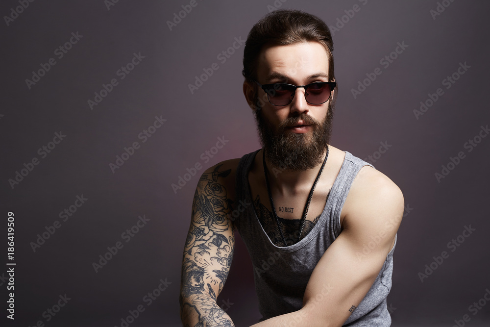 fashionable hipster man with tattoo and sunglasses